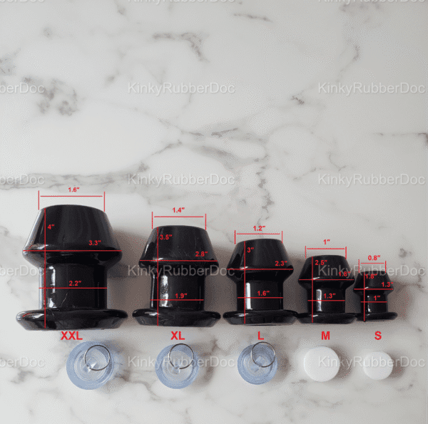 Size comparison of black hollow plugs in five sizes (XXL, XL, L, M, S) with precise measurements labeled in inches, displayed on a marble surface.