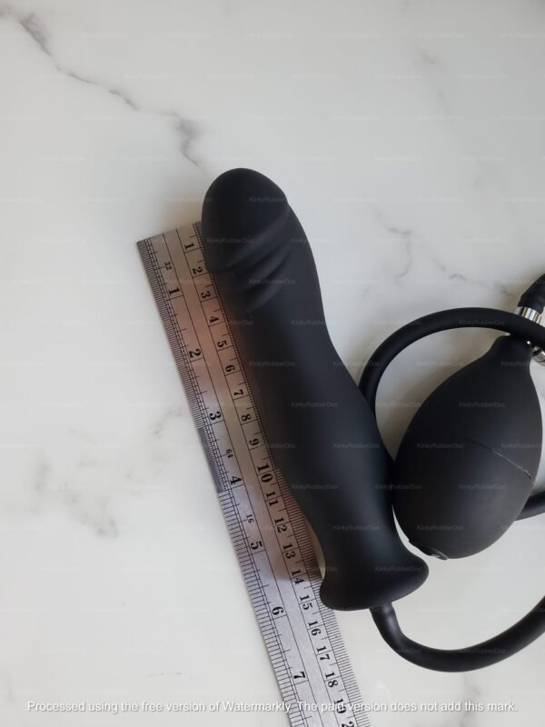 **Alt Text**: Black inflatable silicone butt plug with realistic texture beside a ruler.