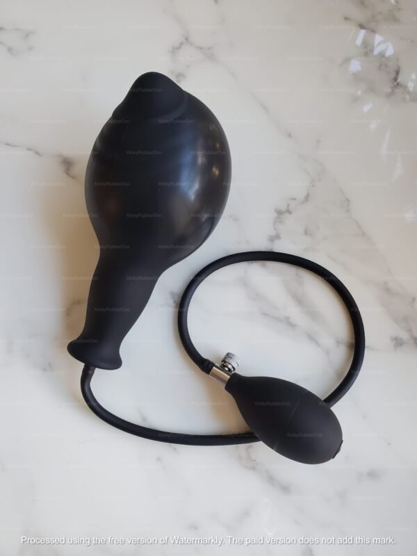 A fully expanded extra-large inflatable silicone butt plug with a connected hand pump, displayed on a marble surface.cc