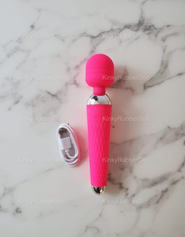 Pink wand vibrator with textured silicone grip and matching USB charging cable on marble surface