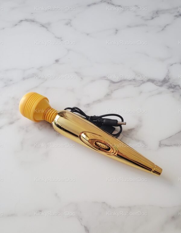 Close-up of gold wand vibrator with yellow silicone head, visible switch, and USB charging cable