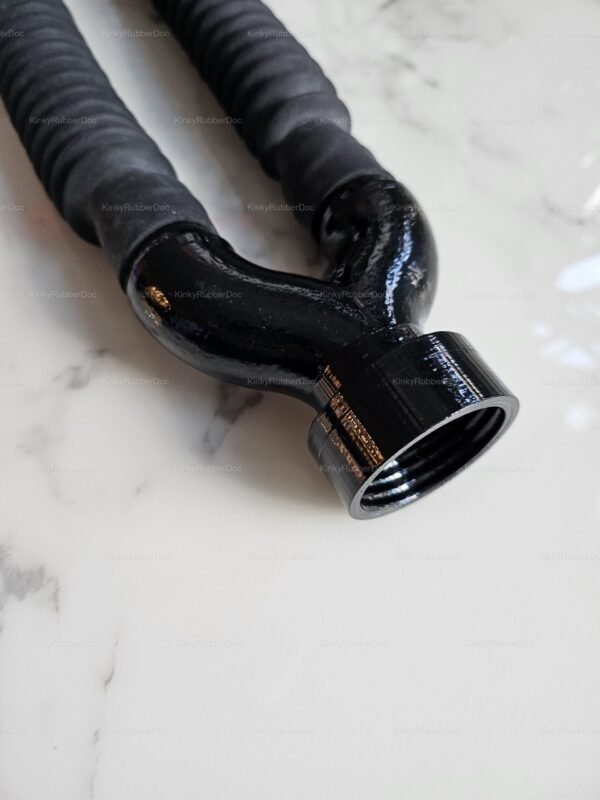 Detailed view of glossy black Y-joint with rubber hoses and threaded female connector on white marble background