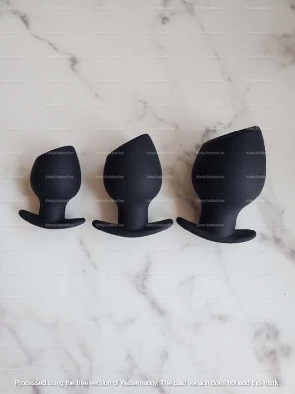 Black silicone hollow plug set with three sizes on a marble surface.