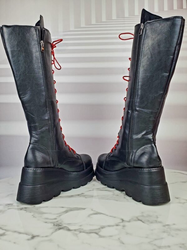 Black leather knee-high boots with red laces and chunky platform soles.