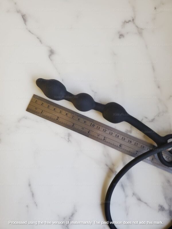 Black inflatable anal beads with cock ring and detachable hand pump on marble background