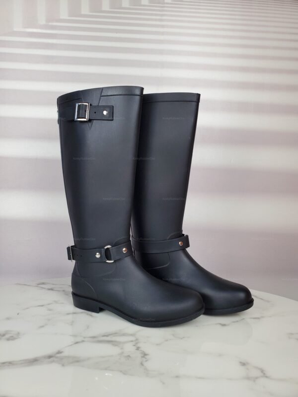 Sleek black rubber knee-high boots with buckle detail and a smooth finish.