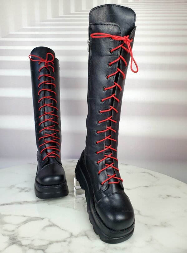 Black knee-high boots with bold red laces, perfect for alternative fashion and fetish wear.