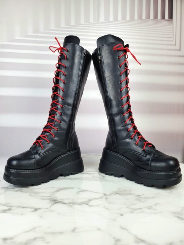 Black knee-high fetish boots with red laces and chunky platform soles.