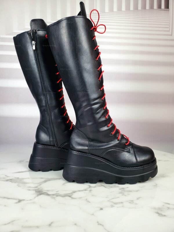 Black leather boots with striking red laces and chunky platform soles.