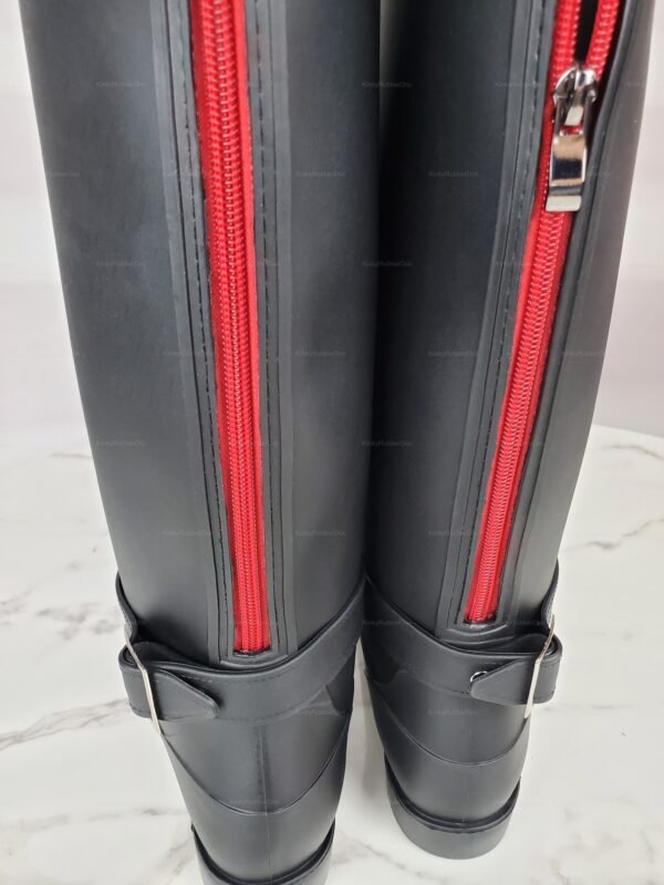 Black rubber boots with striking red zippers and adjustable straps.
