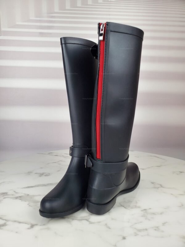 Sleek black rubber boots with striking red zippers and buckle detailing.