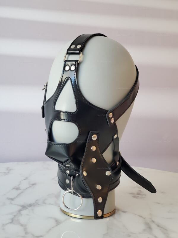 Black leather bondage mask with rivet accents and integrated silicone gag.