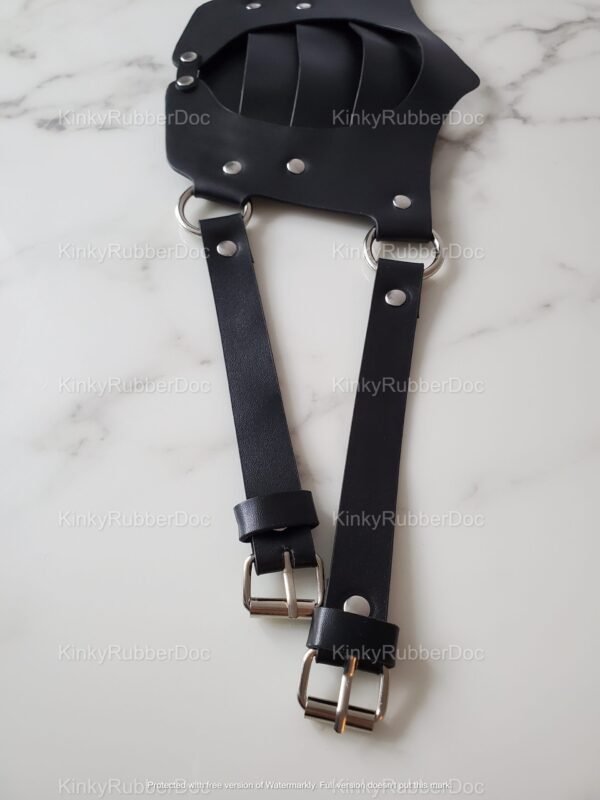 Black leather face mask with adjustable straps and metal hardware, designed for a bold and edgy look.