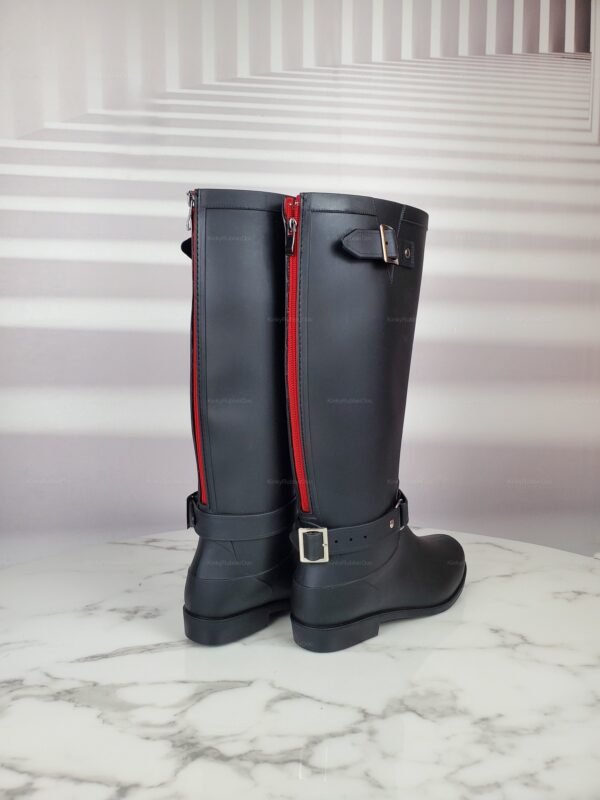Black rubber boots with striking red accents and buckles, ideal for a commanding presence.