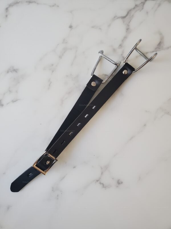 Steel expander gag with leather strap on a marble surface.