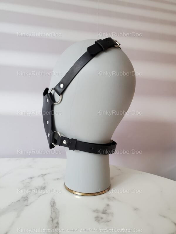 Black leather strap face mask with metal hardware, designed for a bold and daring look.