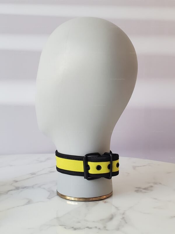 Yellow neoprene collar with black accents on a marble surface.