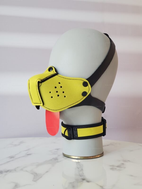 Bright yellow neoprene puppy play muzzle with black straps and red tongue detail.