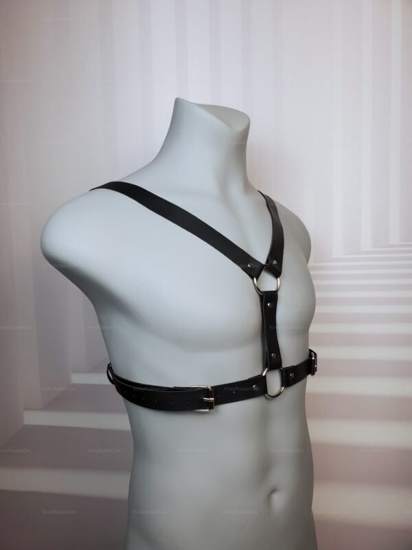 Adjustable black faux leather chest harness with front O-rings and buckle straps, angled front view on mannequin
