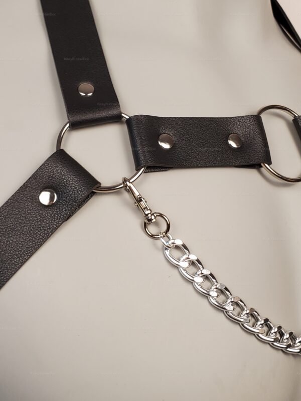 Adjustable leather harness with silver chain accents.