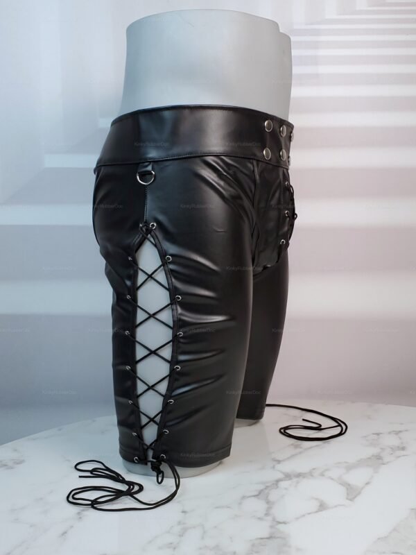 Black faux leather chap shorts with lace-up sides and metal ring accents.