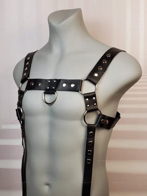 Front view of a black faux leather chest Harness with Suspenders and silver D-rings and adjustable suspender straps.