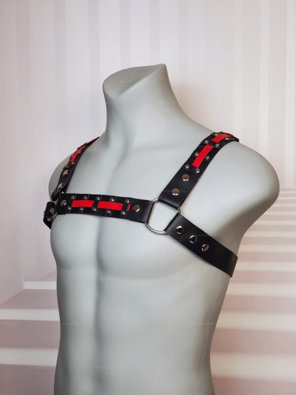 Black and red leather harness with metal rivets and rings for bold fashion statements.