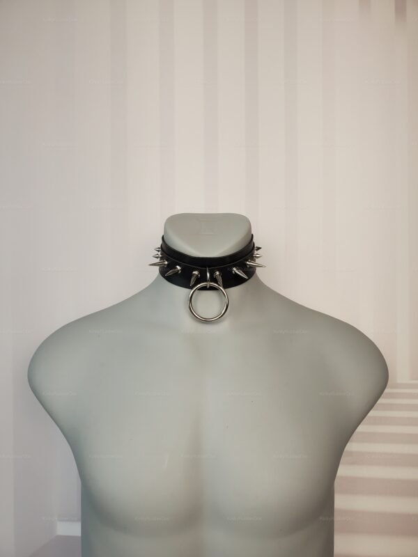 Black spiked collar with metal ring, front view.