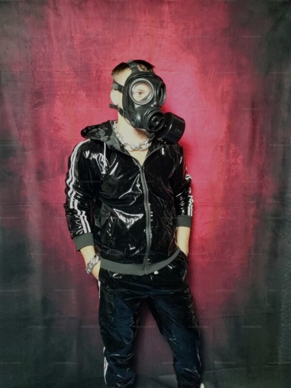 Shiny black PVC tracksuit paired with a bold gas mask against a red and black backdrop.
