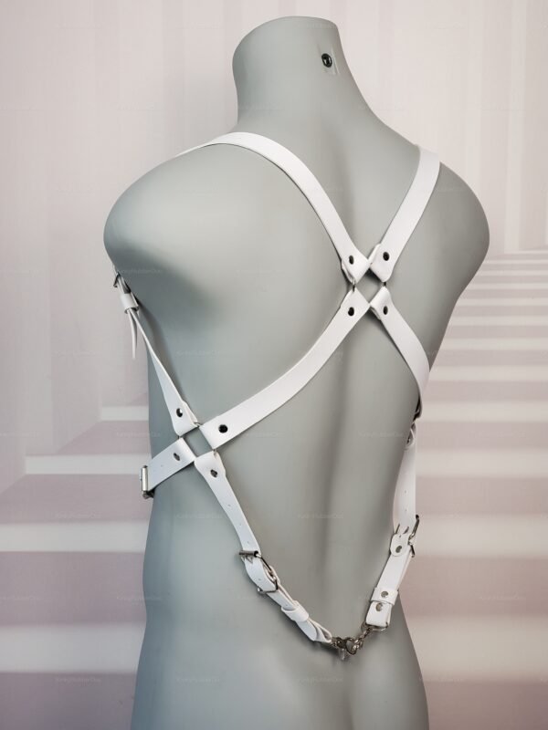 A white faux leather bondage harness with adjustable straps and metal buckles.