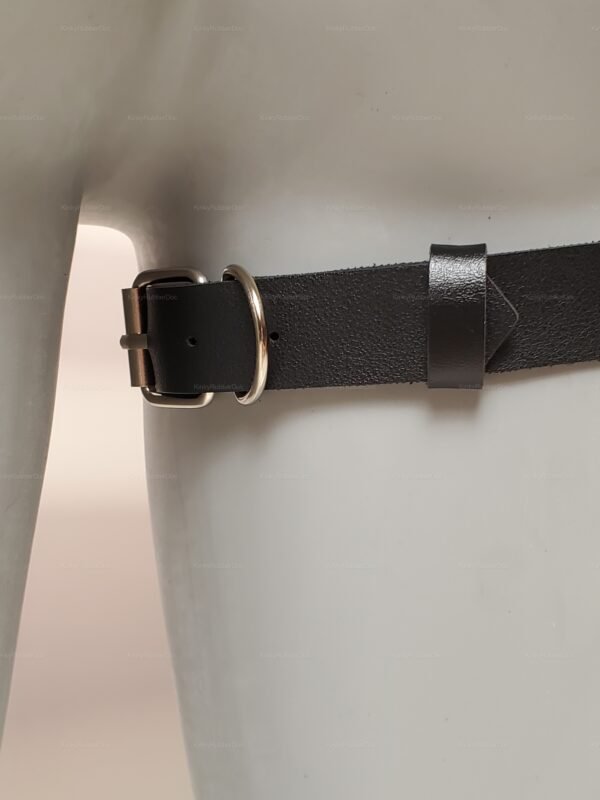 Close-up of black faux leather thigh harness with silver buckle and D-ring connector
