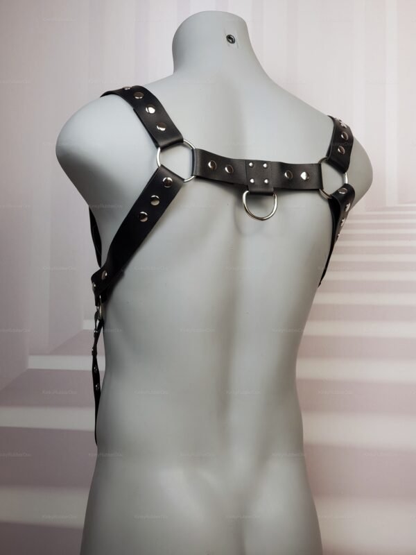 Sleek black leather harness with metal rings and stud detailing.