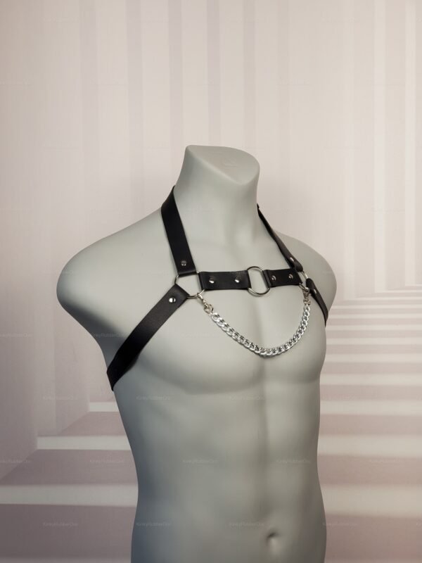 Black leather harness with chain detail and metal ring.