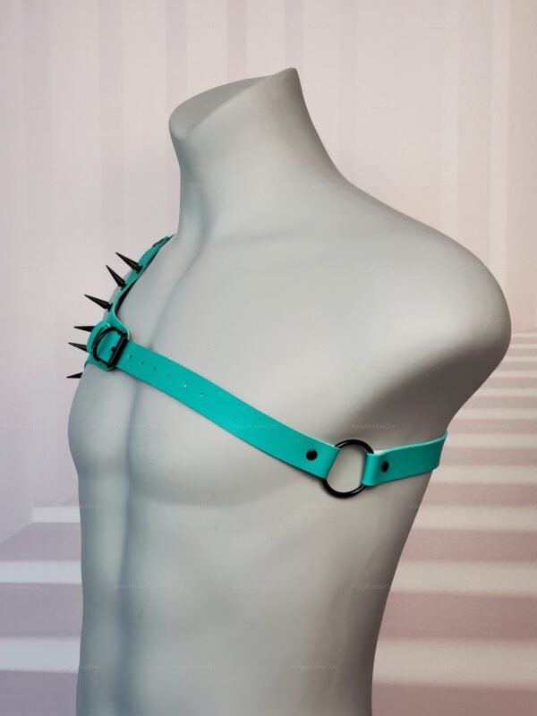 Teal latex harness with spikes and O-ring detail.