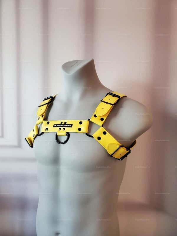 Bright yellow fetish-style harness with adjustable straps and metal ring detailing.