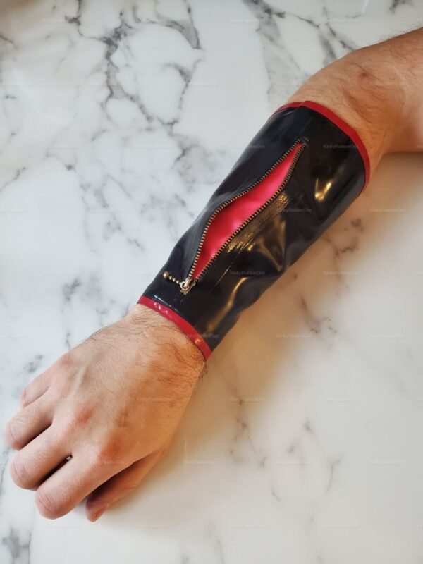 Black latex arm wallet with zipper closure and red accents on a marble surface.