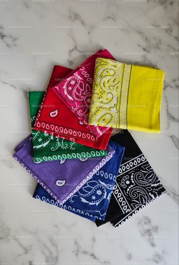 A vibrant set of multicolored bandanas laid out on a marble surface, featuring intricate paisley patterns.