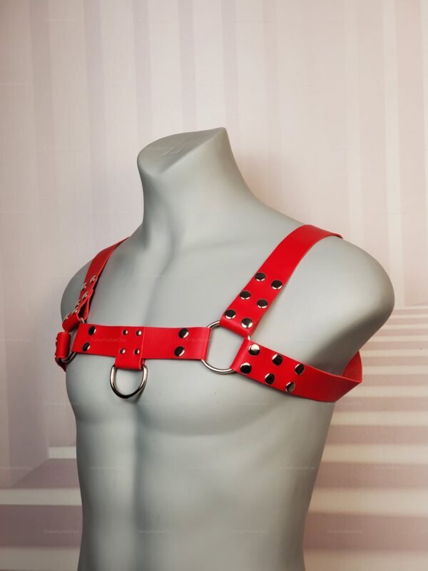 Red Chest Harness with silver studs and D-rings on mannequin, side view.