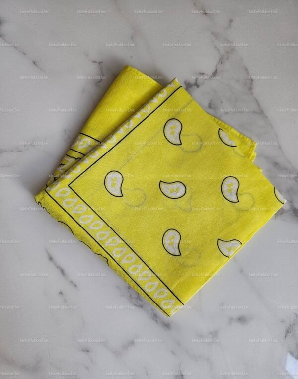 Bright yellow bandana with paisley patterns on a marble surface.