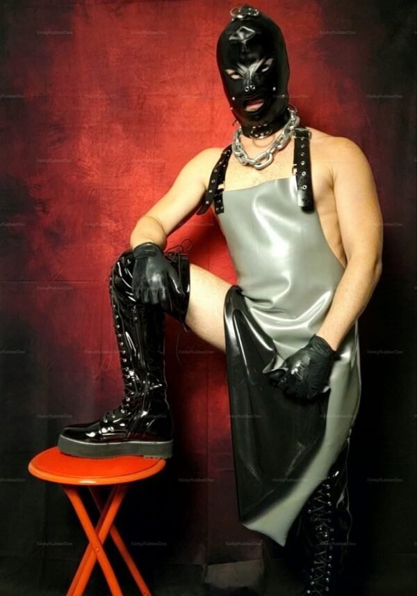 Gray latex apron with black mask and boots, set against a dramatic red background.