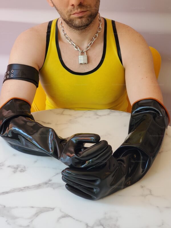 Heavy-duty black rubber gloves on a marble table, paired with a bold yellow top and silver chain.