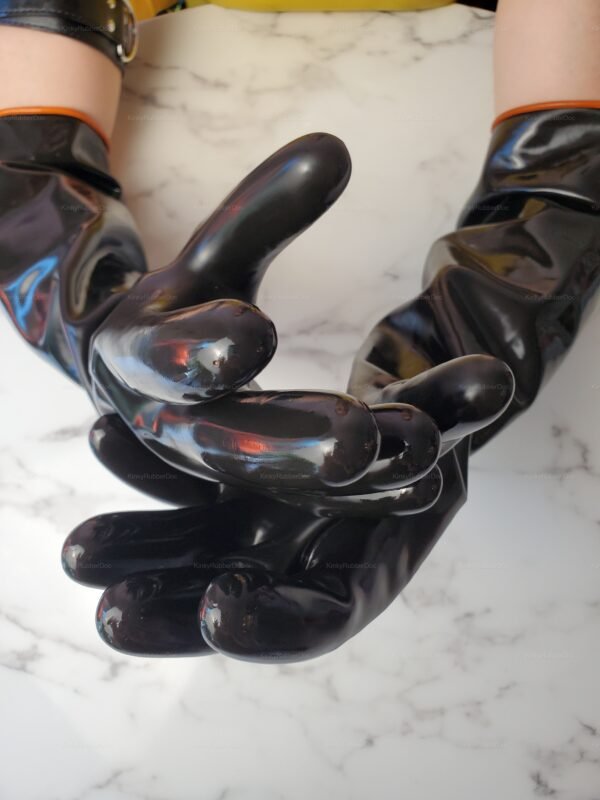 Black latex gloves with extended cuffs, featuring a glossy finish on a marble surface.