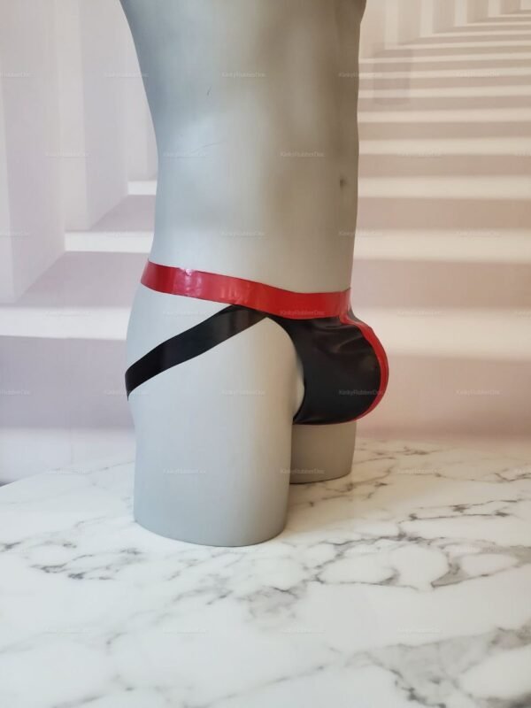 Red and black latex jockstrap on display, highlighting its sleek and glossy finish.