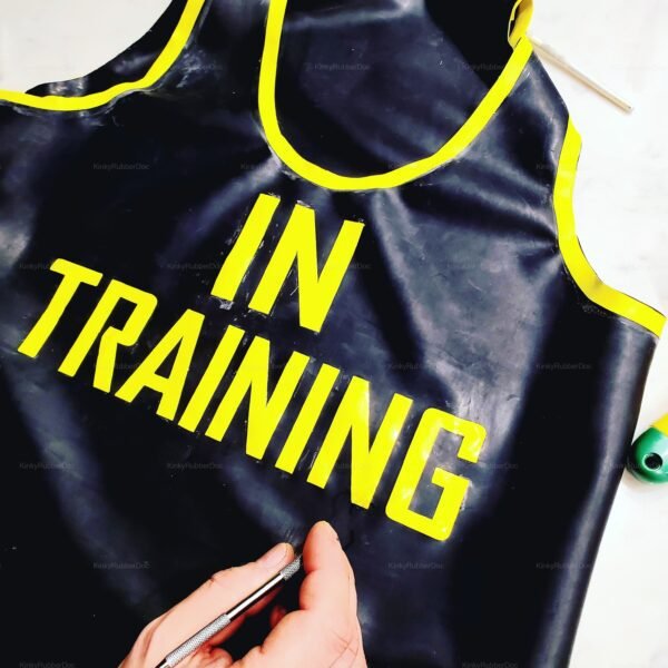 Black latex clubwear shirt with bold yellow "In Training" lettering and trim.