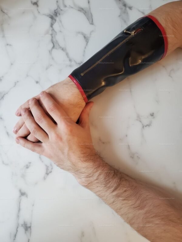 Black latex wrist cuff with red trim, featuring a zipper and snap closures for storage.