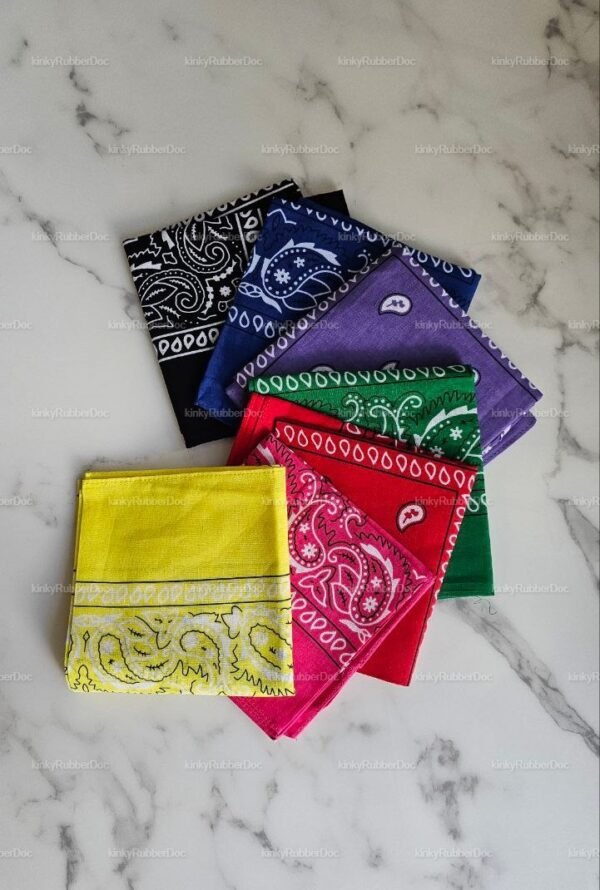 A collection of colorful handkerchiefs in various shades including black, purple, green, red, and yellow, laid out on a marble surface.