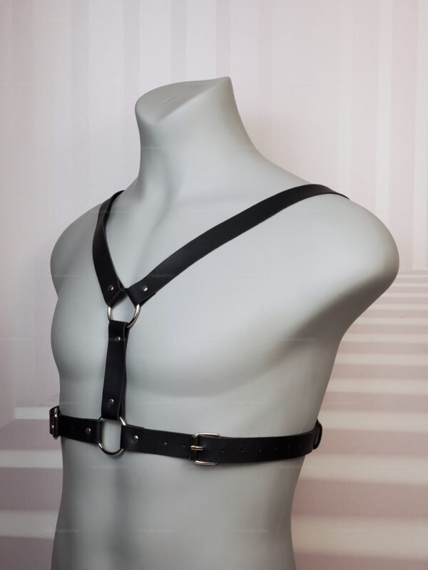 Minimalist black faux leather chest harness with O-rings, front view on mannequin torso