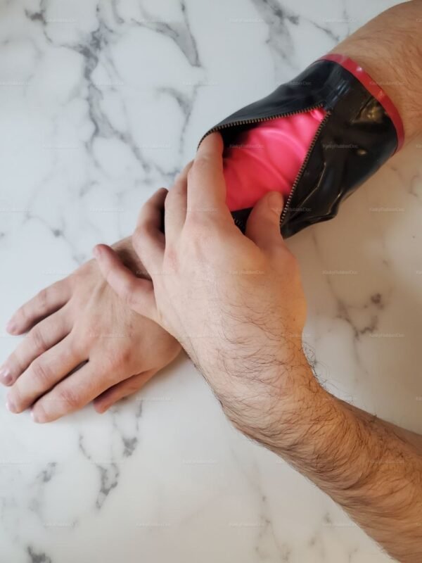 Stylish rubber bracelet with snaps and a zipper, featuring a bold pink interior.