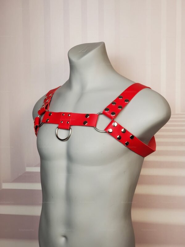 Red leather unisex chest harness with silver D-rings and snap rivet details, queer kinkwear