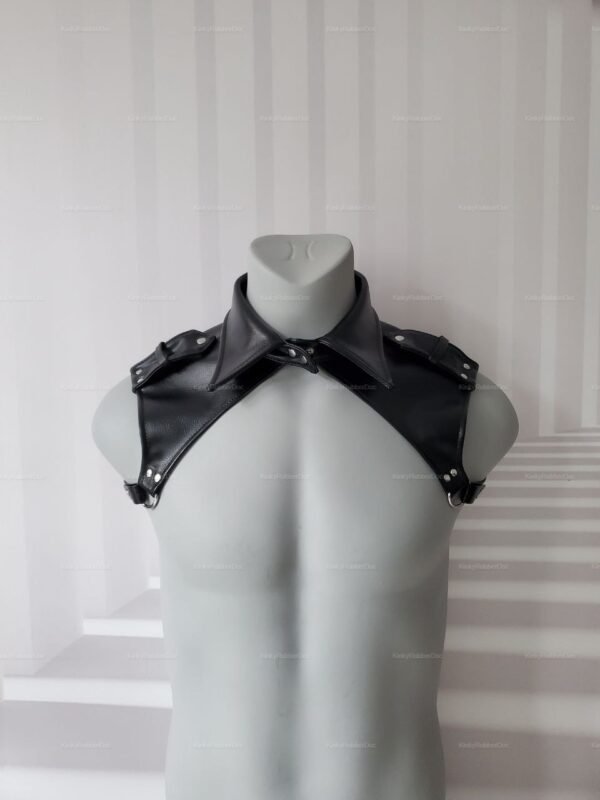 Close-up of a black vegan leather harness with buckle epaulets.